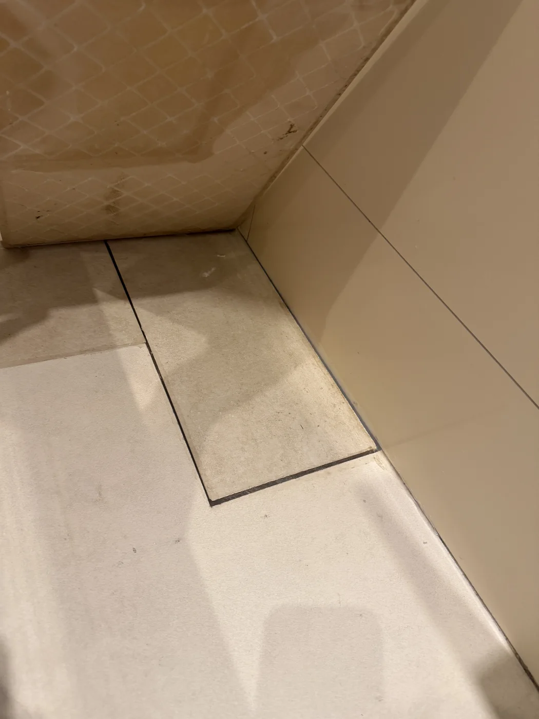 Tiled floor access panel beside the bath